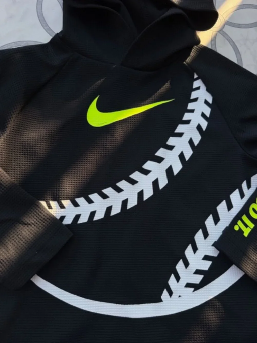 Nike Dri-FIT hoodie featuring a neon yellow swoosh logo and baseball stitching